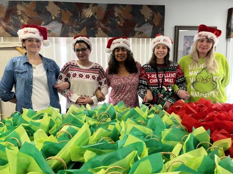 Deby Jo Ferguson • Clay County Progress REACH of Clay County contributes Christmas packages to the Clay County Care Center for the residents. According to Executive Director for REACH Judith Alvarado, “Christmas is most truly Christmas when we celebrate it by giving the light of love to those who need it most.” From left, Sommer Rector and Ashley Harris victim advocate and Judith Alvarado at REACH; Michaela Hildebrand recreational therapist and Beth Stroud, receptionist at Clay County Care Center. 