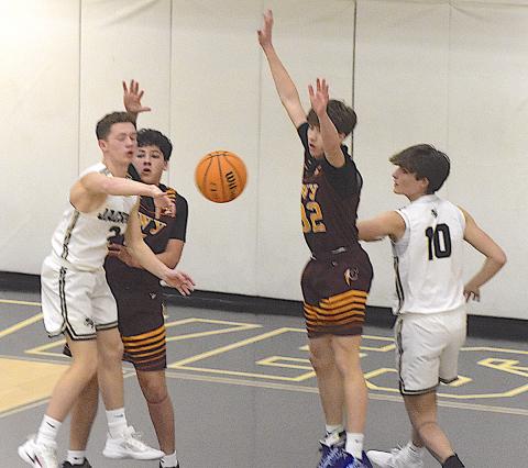 Gary Corsair • Clay County Progress Hayesville's Micah Moss, No. 2, kicks the ball out to a teammate for a 3-point attempt as Daemien Soto, No, 10, fights for position.