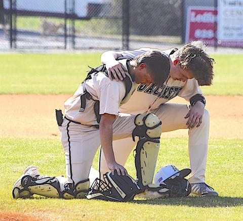 Gary Corsair • Clay County Progress Hayesville battery Chance Hughes and Jackson Sellers pray prior to the beginning of a recent game.