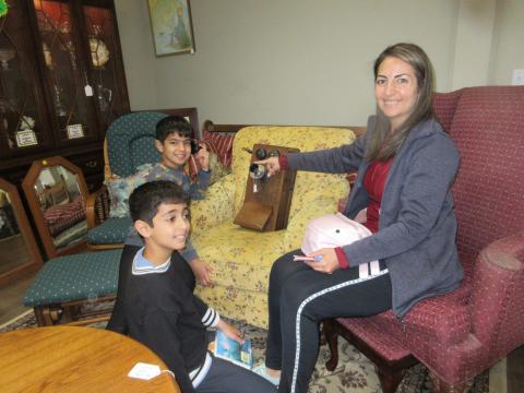 Aiden and Ryan Behnia took time with their mom Asa to  see how to make a call with an antique home phone in the Trash to Treasure showroom.