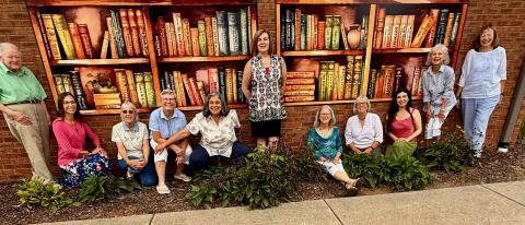 Jennifer Johnson • Moss Memorial Library Friends of the Library Board, from left, are Mary Anne Koos, Marcy Fuerch, Melinda Bradley, Darcy Gerrand, Kat Whitmer, Misty Rutherford, Olivia Anderson, Terry Penland, Amanda Wesson, Dorothy Ethridge and Gwen Christian. Friends admire the new mural on the back wall of Moss Memorial Library.