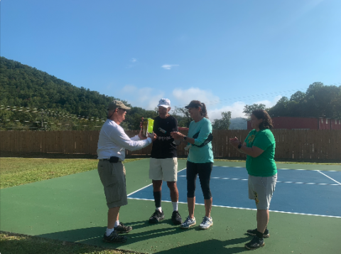 Stecoah Valley Center Board Chair Board Rick Davis presented Patriot Day Pickleball Tournament winners Randy and Shelley Conklin with pickles, pickleballs and Appalachian Roadshow tickets. Also pictured was Karen McCracken, Stecoah Valley Center Program Director and tournament organizer. 