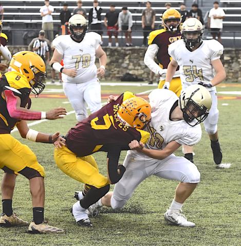 Gary Corsair • Clay County Progress Hayesville's Dustin Lockaby, No. 11, puts a headlock on a Cherokee bar carrier as teammates Devin Ramey, No. 54, and Mason Parker, No. 79, come to help.