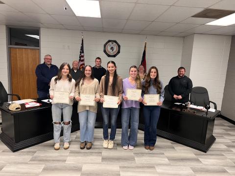Angel Owens • Photo Clay County Schools Board of Education recognized five young women in fall sports, from left, Reese Segars, Aaliyah Jackson, Grayson Williamson, Ave Shook and Savannah Burch received awards in women's volleyball; back, from left, board members Danny Jones, Robert Caldwell, Chairman Jason Shook, Superintendent Melissa Godfrey and Board Member Josh Ashe.