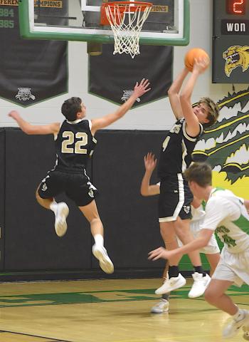 Gary Corsair • Clay County Progress Yellow Jackets guard Eli Cheeks, No. 22, soars through the air as teammate Daemien Soto, No. 4, snares a rebound.