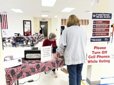 Deby Jo Ferguson • Clay County Progress Election worker Dr. Gail Criss signs in an  early voter Tuesday at the Clay County Board of Elections.