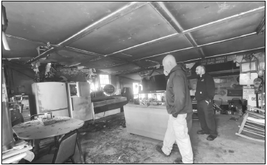Randy Foster/editor@cherokeescout.com Clay County Fire Chief Brian Henderson, left, takes a phone call as assistant fire chief Chris Denton stands by inside Clay’s Corner, which was damaged in a fire Friday afternoon.