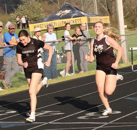 Neal Wachob• Clay County Progress Hayesville's Marlo Joyce,right, give her all in a near photo finish in the 300-meter hurdles. Joyce finished just :00.28 behind the winner.