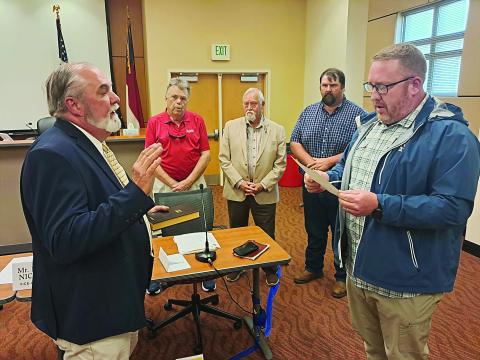Becky Long • Clay County Progress William “Bill” Carter receives the oath of office from County Commission Board Chairman Rob Peck as commissioners, from left, Scotty Penland, Clay Logan and Randy Nichols observe. April 2 was Carter’s first meeting in his official capacity of commissioner.