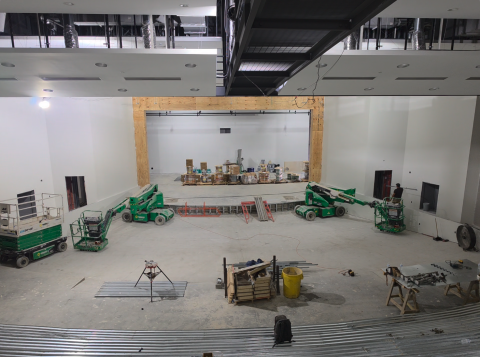 An interior look at the new auditorium shows the base for tiered seating, catwalk at the top of photo ready for paint and work continuing around stage area.
