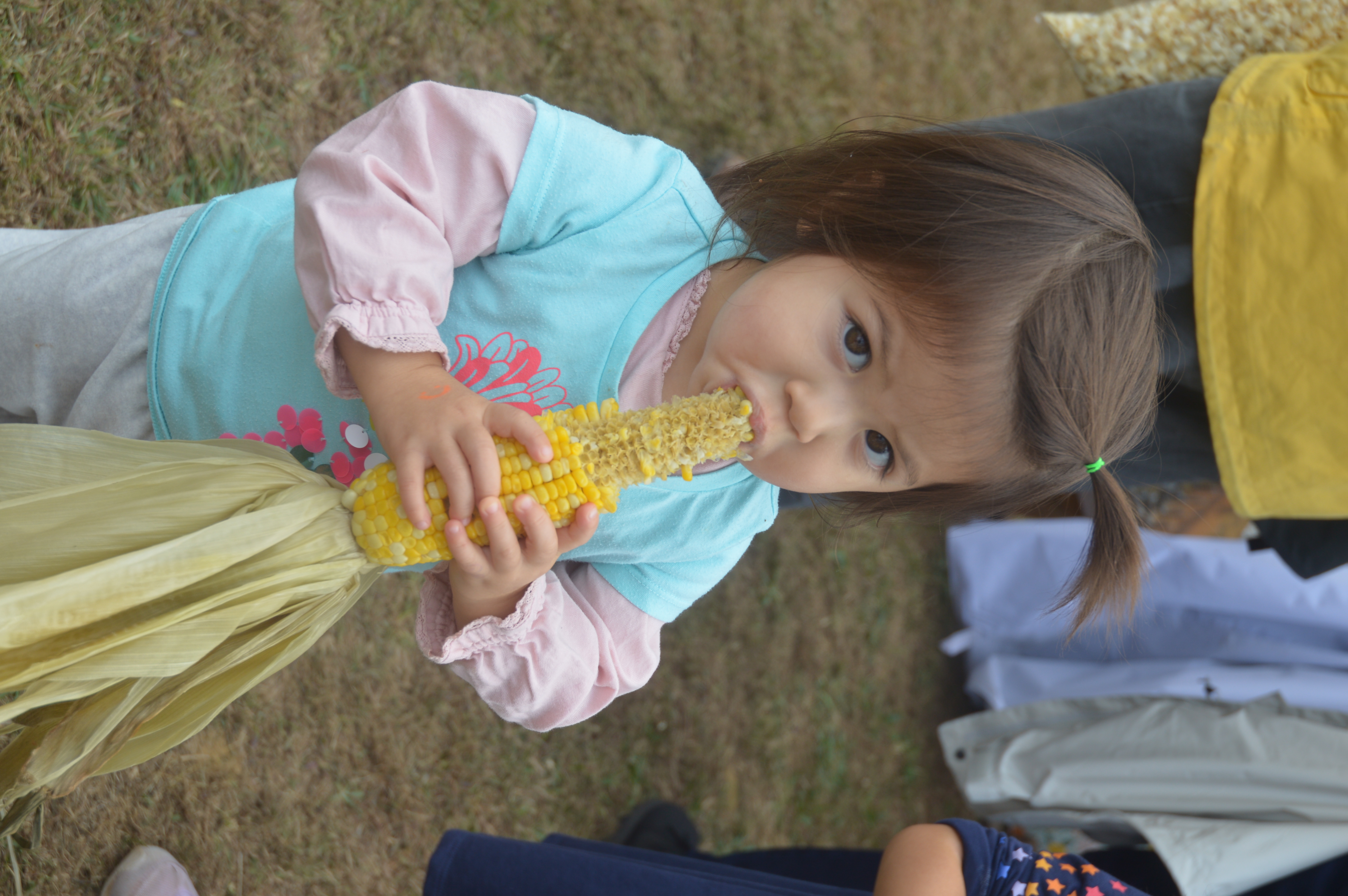 "Beanie" whose family came to the event from out of town, enjoys the hot roasted corn on a cold, rainy Saturday.