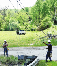 Becky Long • Clay County Progress Blue Ridge Mountain EMC workers survey the damages after a pickup truck struck a three-phase power pole on Myers Chapel Road Tuesday afternoon. The truck can be seen to the left of the damaged pole.