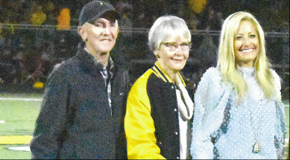 Gary Corsair • Clay County Progress Parents Steve and Jan join Julie Stackhouse on the football field during a halftime ceremony marking her record-holding accomplishments at Hayesville High School. 