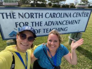 Ginger Scerri and teacher Barbara Rodriguez pose by the sign for North Carolina Center for the Advancement of Teaching in Ocracoke, N.C. Scerri spent most of the week with 23 other teachers from around the state to share and learn from each other.