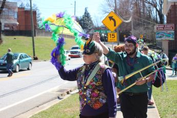 Megan Broome/The Clayton Tribune. Teri Dobbs goes all-out and dances in the One Man Band parade for the second annual Mardi Gras sponsored by the Rabun County Chamber of Commerce on Saturday, Feb. 22. Kaleb Wilburn plays the trombone as the group travels through downtown Clayton.
