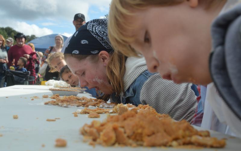 (Lorrie Ross• Clay County Progress) Daily pumpkin pie eating contests gather dozens of people to cheer on their favorite pie eaters. The competition sometimes gets fierce between siblings or friends eating pie side by side.
