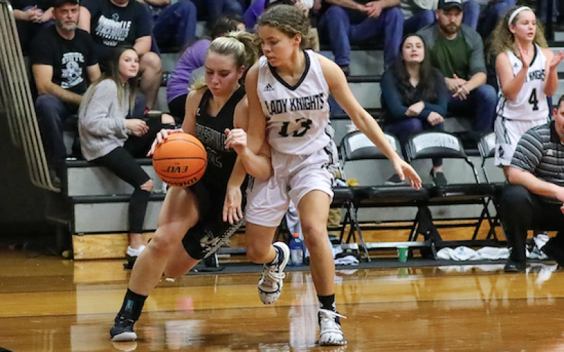 (Kelli Graves • Clay County Progress) Sophomore Lila Payne lowers a shoulder and drives past a Lady Knight and towards the basket.