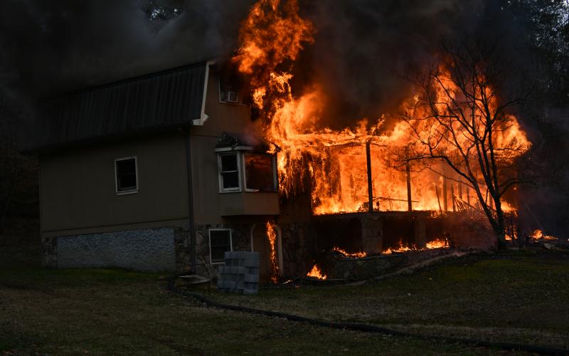 (Photo by Joe Davenport) Upon arrival to the home on Hot House Road, firefighters discover the house is fully involved and not safe to enter. 