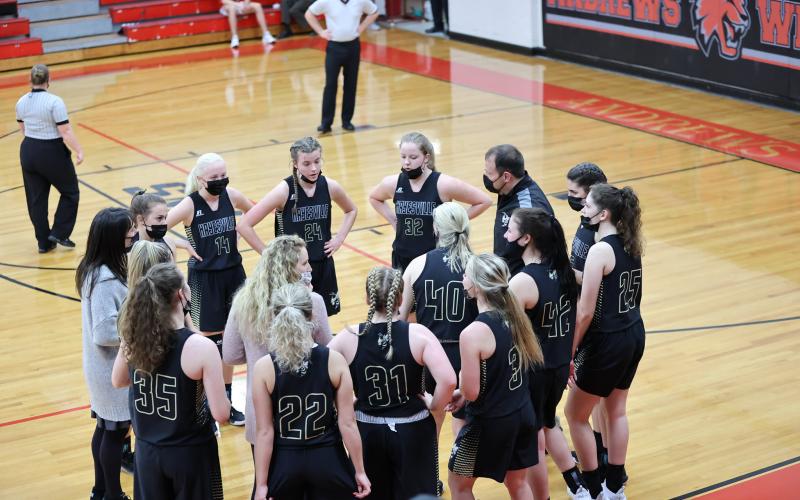 (Kelli Graves • Clay County Progress) Coach Chad McClure and his staff take advantage of a mask timeout to go over the game plan against the Lady Wildcats.