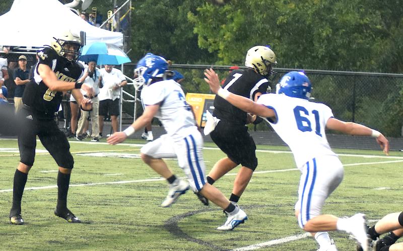 Logan Caldwell, No. 6, dumps a short pass over Towns County defenders while Kyle Lunsford, No. 7, provides protection.