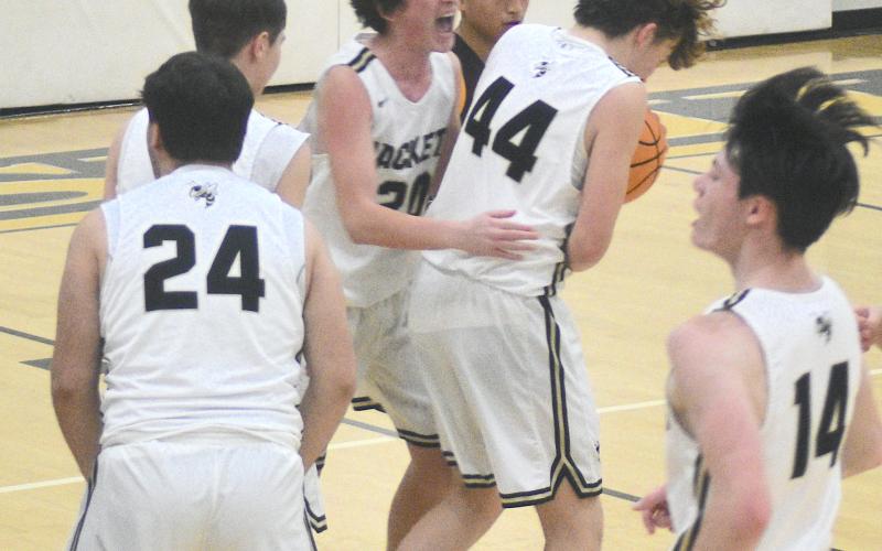 Brady Jones, No. 20, bear hugs Jackson Sellers, No. 44, after the big guy snared the rebound on Cherokee's shot at the buzzer. Michael Colandrea, No. 24, and Slade Crouch, No. 14, join the Hayesville celebration.