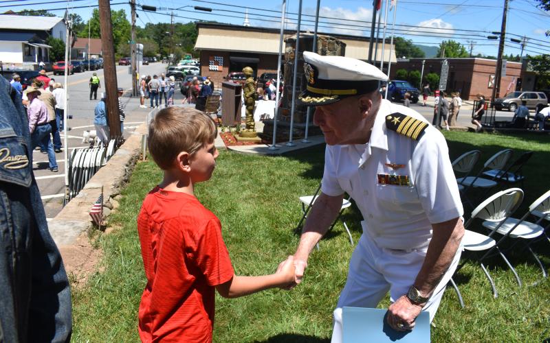 Becky Long • Clay County Progress Johnny Brown, 8, gets a warm handshake from Captain James P. Davis after Monday’s Memorial Day Service on the Hayesville square. Brown, one of few young people in the audience, said of the service, “It was good.” Davis reminded attendees that Memorial Day is more than the beginning of summer, that it serves a much greater purpose, honoring our war dead.
