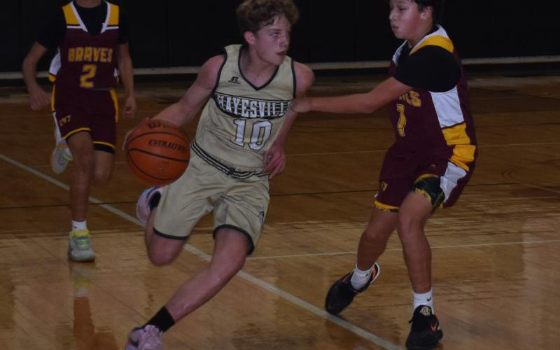 Hayesville Middle School Jacket Kabe Shaheen drives ball down court.