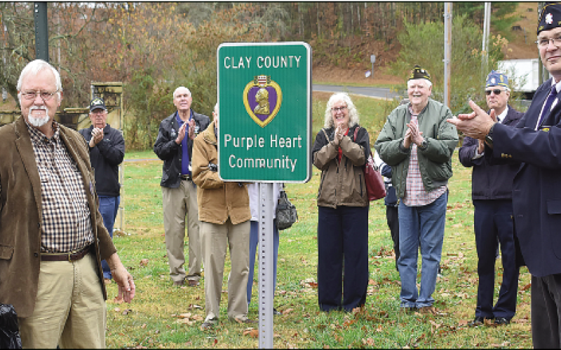Becky Long • Clay County Progress County Commissioner and veteran Clay Logan joins American Legion Commander Robert Seibert and other veterans for the unveiling of the sign marking Clay County as a Purple Heart Community. Five signs with the designation will be placed in the county.