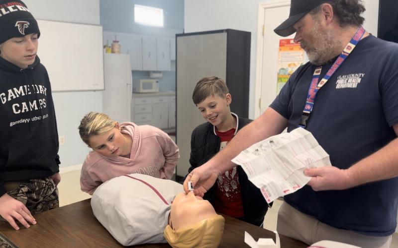 Community Paramedic Ben English demonstrates life-saving techniques to training attendees Dustin Lockaby, Emma-Layne Lockaby and Kanyon Lockaby.  English was among several instructors involved in the “First on the Scene,” training.