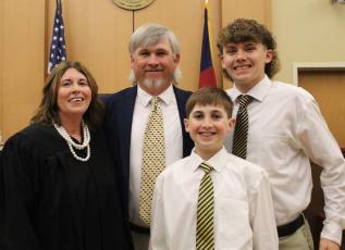 Photo by Carissa Daniels From right, Senior Resident Superior Court Judge for North Carolina District 43A Tessa Sellers, her husband, Joe Jack Sellers and sons, Rhett and Jackson celebrate Tessa accepting her position.