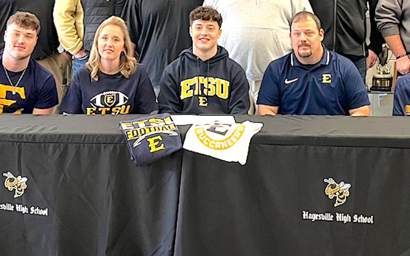 Hayesville two-way football standout Taylor McClure is all smiles after signing a letter of intent to play Division 1 football at East Tennessee State University in Johnson City, Tenn. Taylor, is flanked by parents Keisha and Chad McClure and joined by older brother Blake and younger brother Caden. Taylor is one of nine incoming freshman signees at ETSU.